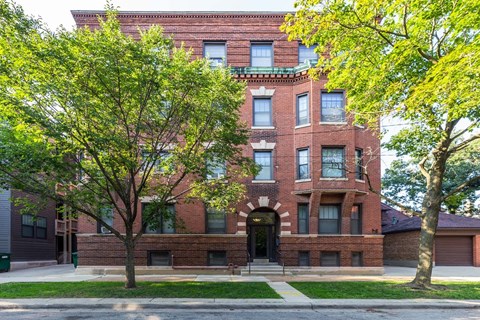 A red brick building with a black door and windows.