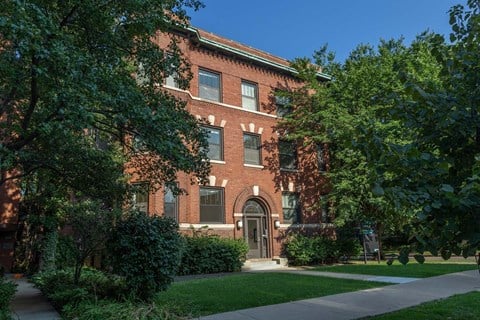 A red brick building with a green lawn in front.