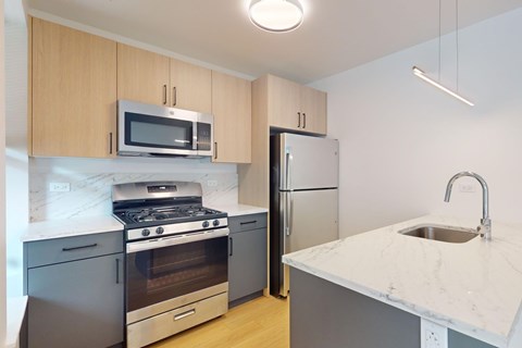A kitchen with a stove, oven, refrigerator, and microwave.