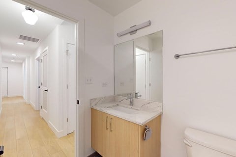 A bathroom with a sink, mirror, and bathtub.