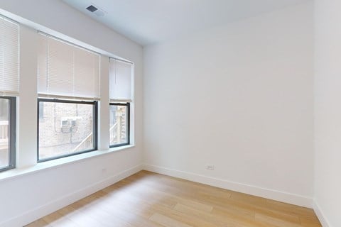 A room with a window and a wooden floor.