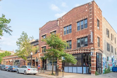 A red brick building with a blue door and a mural on the side.