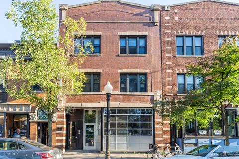 A brick building with a tree in front of it.