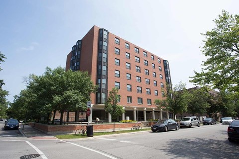 A red brick building with a parking lot in front.
