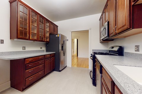 A kitchen with wooden cabinets and a black refrigerator.