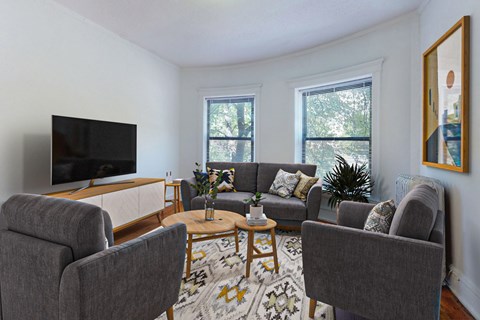 A living room with grey couches and a television.