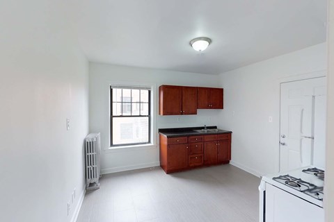 A kitchen with white cabinets and a window.