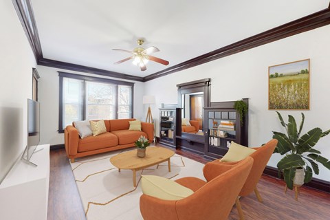 A living room with a brown couch, a white coffee table, and a ceiling fan.