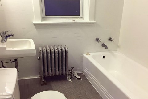 A white toilet sits next to a white sink in a bathroom.