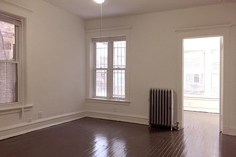 A room with a window and a radiator on the floor.