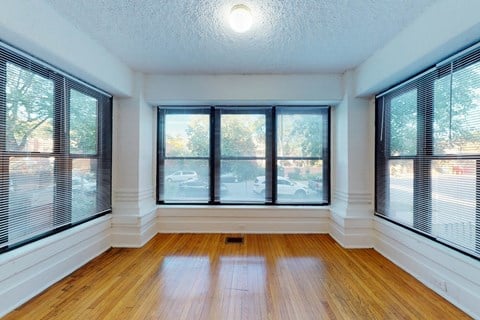 A room with wooden floors and large windows.