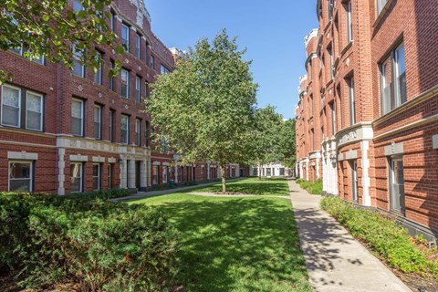 A long, narrow walkway between two rows of red brick buildings.