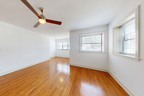 A room with wooden floors and a ceiling fan.