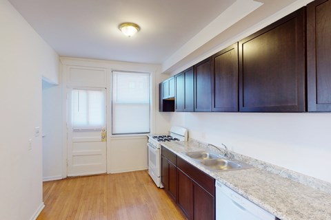 A kitchen with dark brown cabinets and a white stove top oven.
