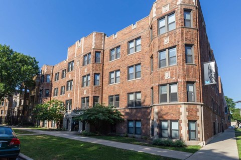 A large red brick building with a green lawn in front.