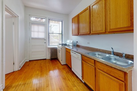 A kitchen with wooden cabinets and a white dishwasher.