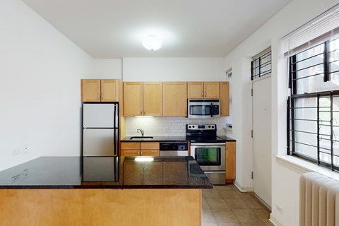 A kitchen with wooden cabinets and a black countertop.