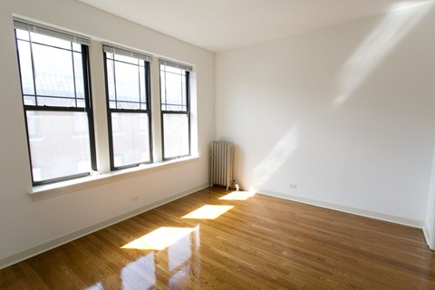 A room with a window and a radiator on the floor.