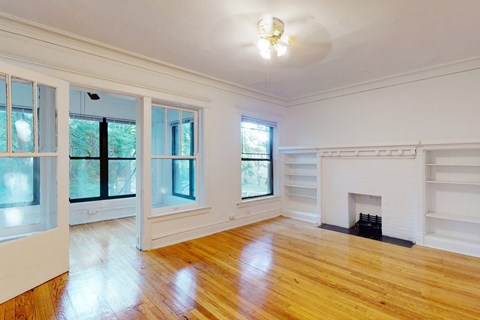 A room with a fireplace and wooden floors.