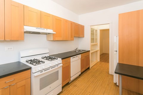A kitchen with wooden cabinets and a white stove top oven.