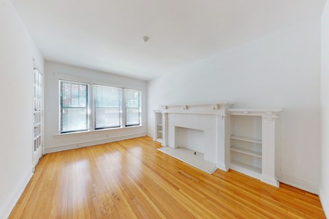 A room with a fireplace and wooden floors.