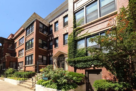 A red brick building with ivy growing on the side.