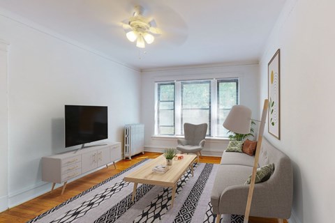 A living room with a television, a chair, a couch, and a coffee table.