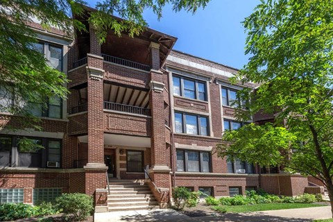 A large red brick building with a balcony on the second floor.