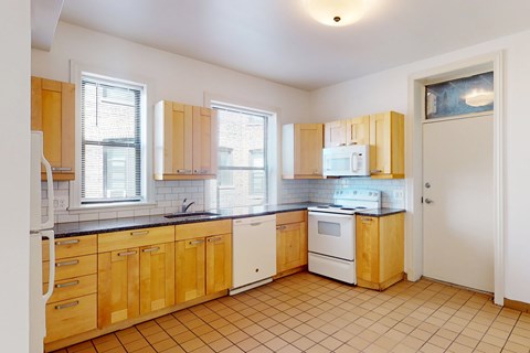 A kitchen with wooden cabinets and white appliances.