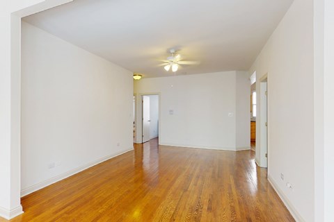 A room with wooden floors and a ceiling fan.