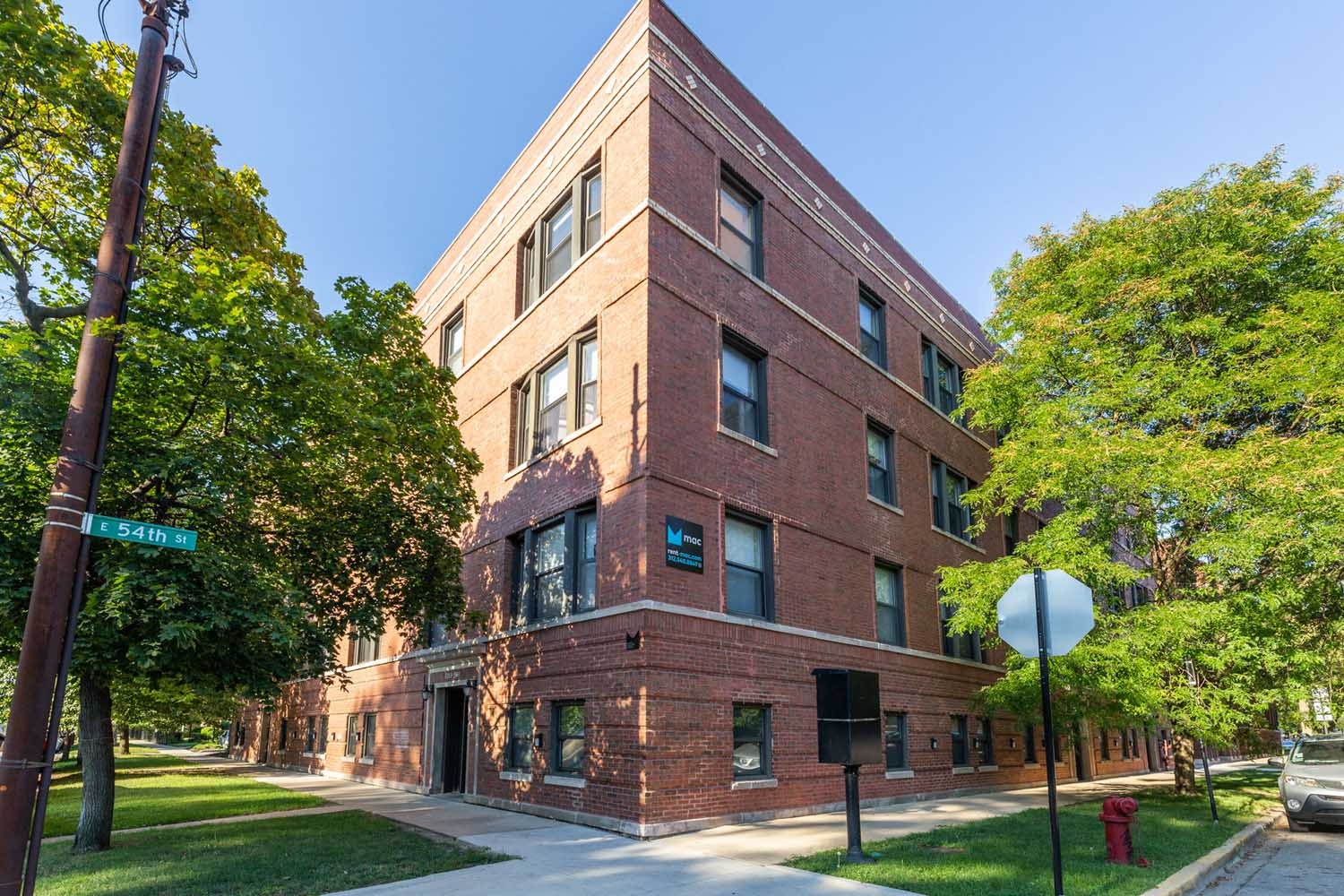 A red brick building with a green lawn in front.