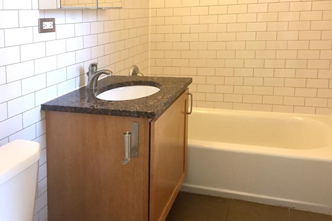 A bathroom with a sink, toilet, and bathtub.