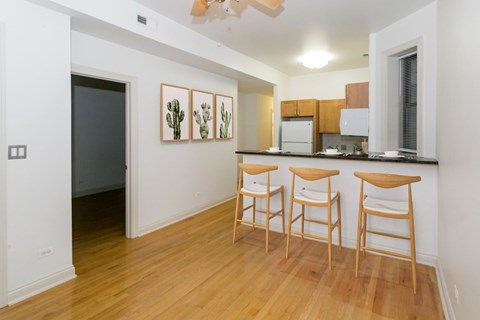A kitchen with a bar stool and a fridge.
