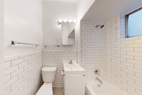 A white bathroom with a toilet, sink, and bathtub.