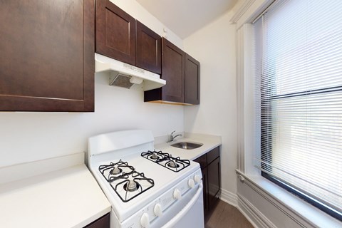 A white stove in a kitchen with brown cabinets.