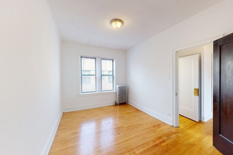 A room with a window and a radiator on the floor.