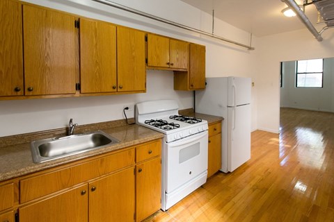 A kitchen with wooden cabinets and a white stove top oven.