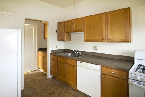 A kitchen with brown cabinets and white appliances.