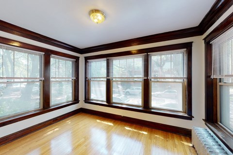 A sunny room with wooden floors and windows.