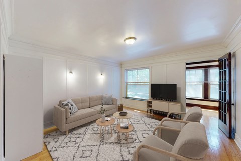 A living room with a grey couch, a coffee table, and a television.