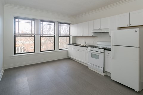 A kitchen with white appliances and cabinets.