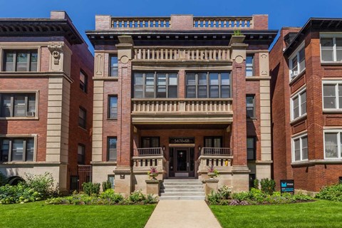 A large red brick building with a black door and windows.