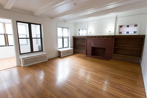 A large empty room with wooden floors and white walls.