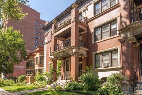 A red brick building with a balcony in the middle.