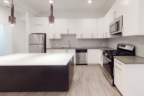 A modern kitchen with a stainless steel refrigerator and a white countertop.