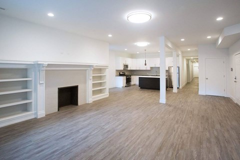 A spacious living room with a fireplace and hardwood flooring.