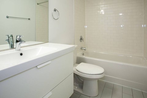 A white bathroom with a toilet, sink, and bathtub.
