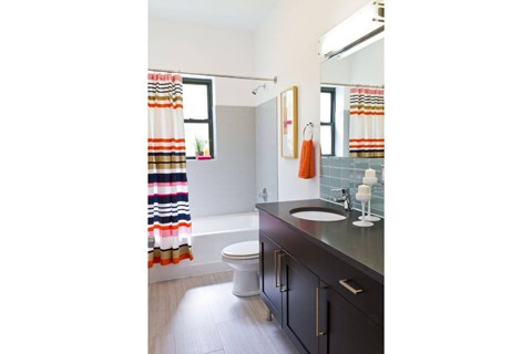 A bathroom with a toilet, sink, and a shower curtain.