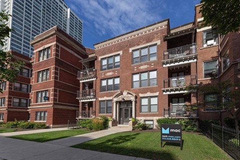 A brick building with a sign in front that says mac.