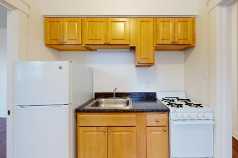 A kitchen with wooden cabinets and a white refrigerator.